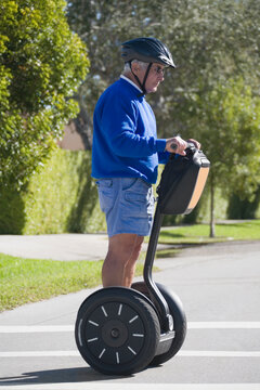 Side profile of a senior man riding a segway