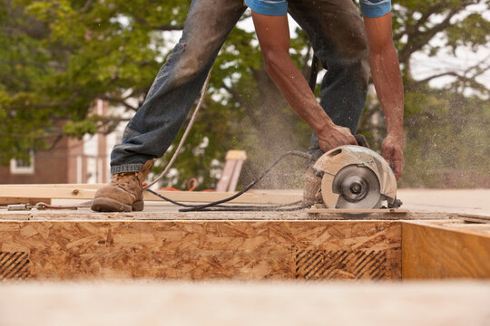 Carpenter sawing a particle board