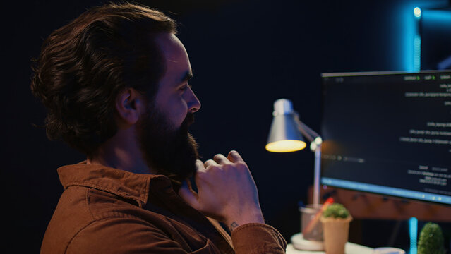 Happy self employed developer in home office doing coding on computer at desk. Joyful IT specialist doing contracted job from apartment, writing lines of code at workstation. close up.