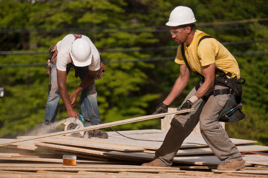 Carpenters trimming a particle board
