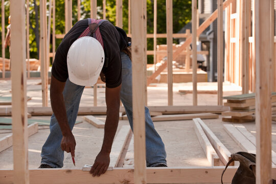 Carpenter marking measurements on wood