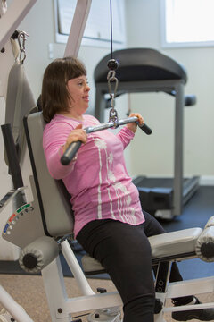 Girl with Down Syndrome working out on an exercise machine
