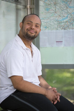 Man with Down Syndrome sitting at a bus stop