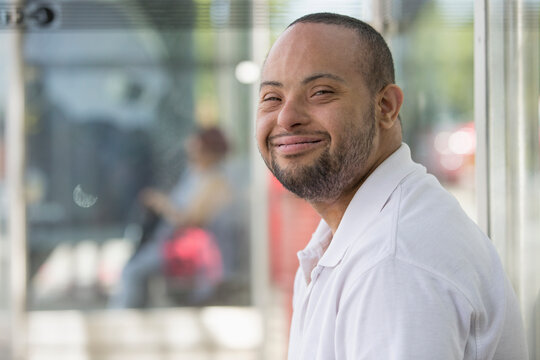 Man with Down Syndrome sitting at a bus stop