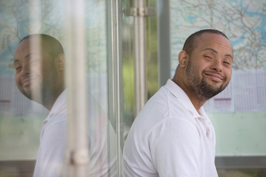 Man with Down Syndrome sitting at a bus stop