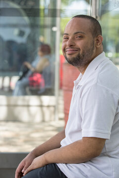 Man with Down Syndrome sitting at a bus stop