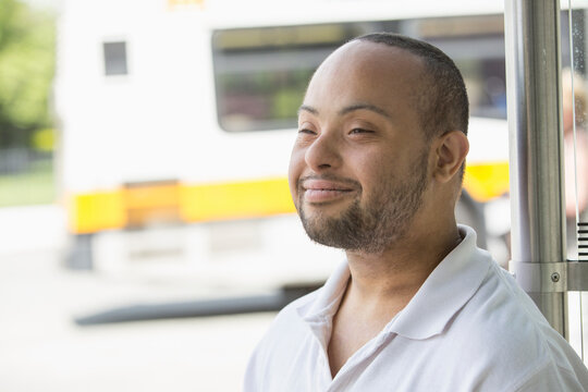 Man with Down Syndrome sitting at a bus stop