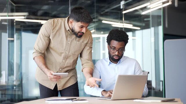 Manager standing and praising employee sitting at office desk with laptop for excellent work. Positive workplace interaction showing appreciation, motivation and professional corporate recognition