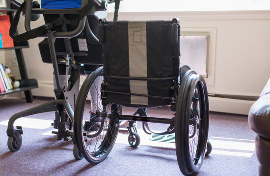 Woman with spinal cord injury getting into her desk so she can stand up
