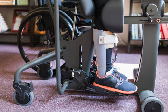 Woman with spinal cord injury getting into her desk so she can stand up