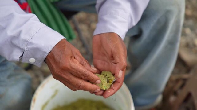 An angler intently preparing bait.