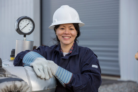 Portrait of female power engineer with pressure sensor at power station