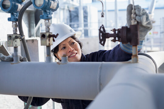 Female power engineer checking pressure transducers at power plant
