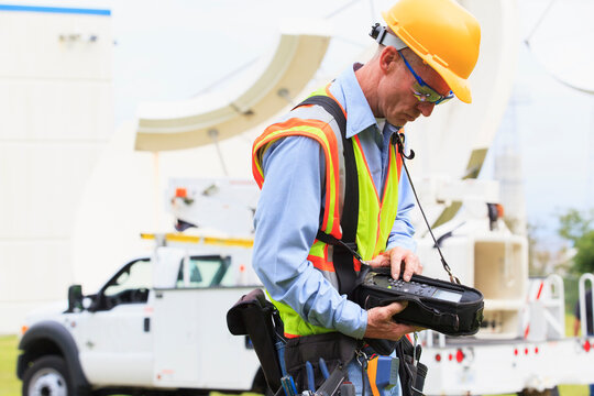 Communications engineer preparing measuring instrument for satellite antenna alignment