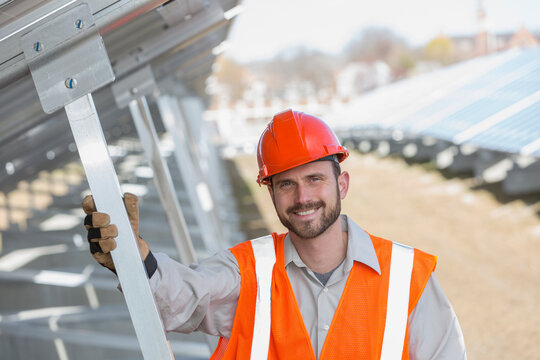 Power engineer standing underneath solar photovoltaic array