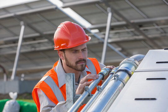 Power engineer examining conduit at solar photovoltaic array