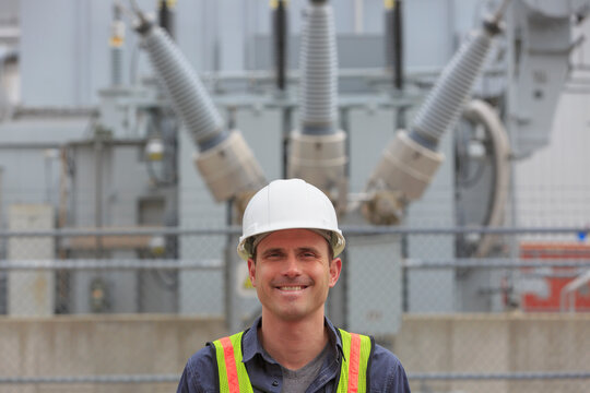 Industrial engineer in front of high voltage transformer at a power plant