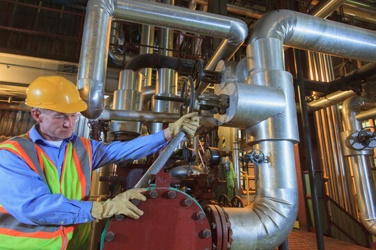 Engineer in electric power plant inspecting condenser piping