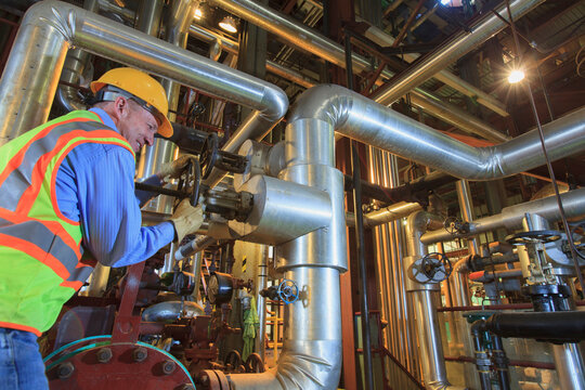 Engineer in electric power plant adjusting condenser piping valve