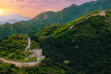 Fototapeta premium Beijing, China Great wall curving over forested ridges at dusk
