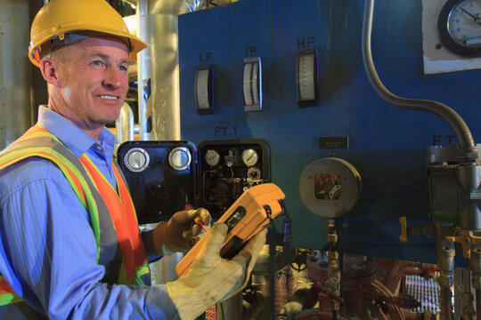 Engineer in electric power plant using a voltmeter to verify sensor readings