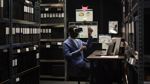 African American private detective investigates a questionable case, gathering clues and evidence using modern technology. Police officer utilizing virtual reality glasses to analyze criminal records.