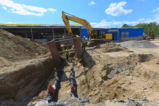 Excavator and trench shield for construction workers at water pipe laying site