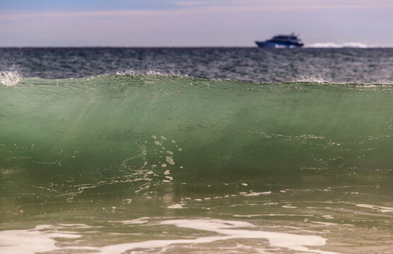 Breaking wave on Crescent Beach with high speed ferry in background