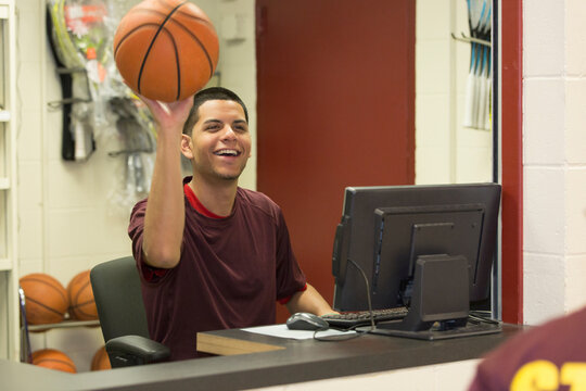 Supervisor holding a basketball in college equipment dispensary