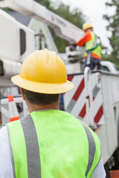 Utility workers preparing to work on power lines in a bucket truck