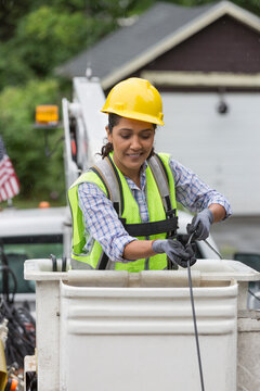 Hispanic female cable lineman stringing a new line