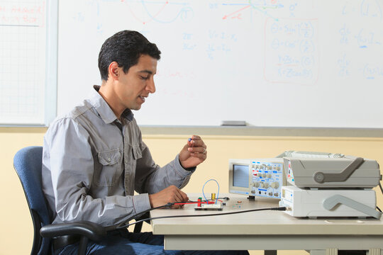 Engineering student preparing prototyping breadboard for an electronics lab experiment