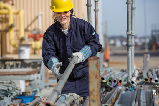 Female power engineer sorting through scaffolding at power plant