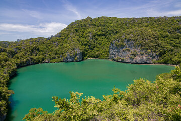 Fototapeta premium Panoramic view of Talay Nai emerald lagoon and surrounding limestone cliffs at Ko Mae Ko island in Mu Ko Ang Thong, Thailand
