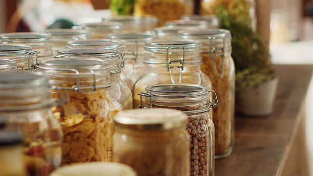 Close up on bulk products in recyclable glass containers used by zero waste supermarket to eliminate single use plastics, with local store pantry staples in sustainable packaging, zoom out shot.