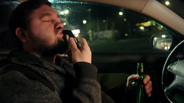 Night scene with breath analysis under city lights. Driver tests breathalyzer inside car at night. Bearded caucasian man checks his breath alcohol device while parked. Prevention of drunk driving