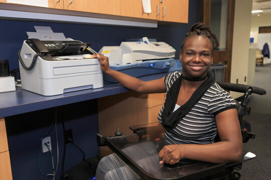 Teen with Cerebral Palsy using copier at office