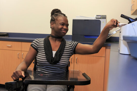 Teen with Cerebral Palsy using copier at office