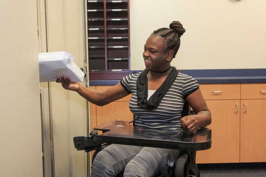 Teen with Cerebral Palsy getting copy paper