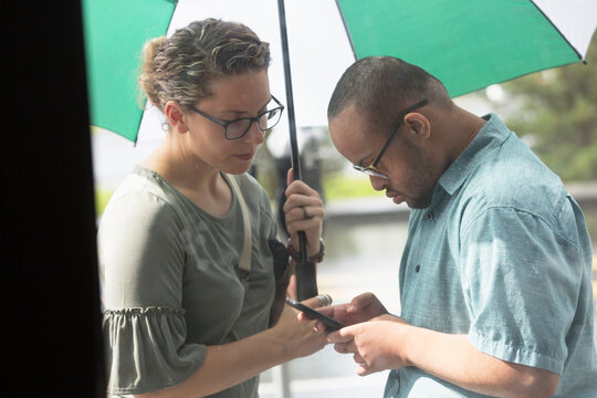 African American man who has Down Syndrome looking at his phone with his friend