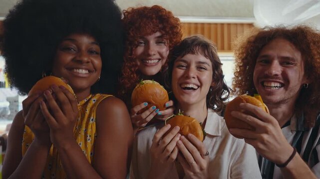 Multiethnic group of friends having meal at 80s vintage diner restaurant - Multiracial young people bonding and having fun, eating in an american fast food burger house
