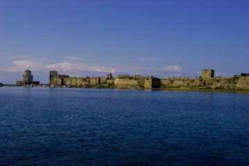 Obraz premium Methoni Castle and Fortress in Greece on a clear day with boats in the harbor.
