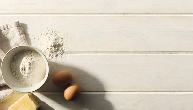 Baking ingredients and essentials for creating delicious homemade treats and pastries on light wooden table for copy space