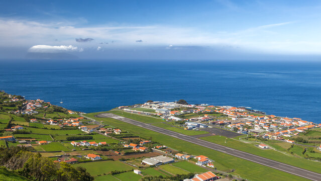 Vista a&eacute;rea panor&aacute;mica de Santa Cruz das Flores y su aeropuerto, en la isla de Flores, Azores, con el oc&eacute;ano Atl&aacute;ntico y la isla de Corvo al fondo