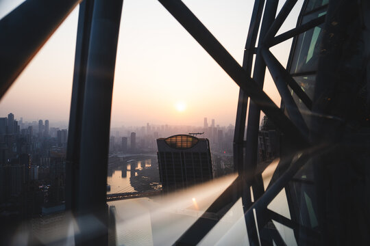 City and river at sunrise seen through a geometric glass structure