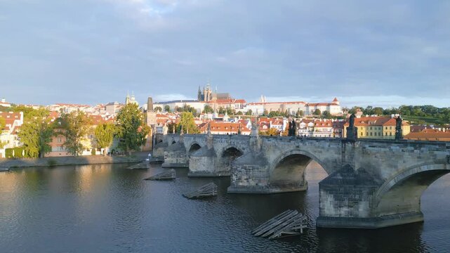 Experience the beauty of Charles Bridge and Prague Castle in a stunning aerial view. The morning light brings out the charm of the Vltava River and historic architecture in Czechia.