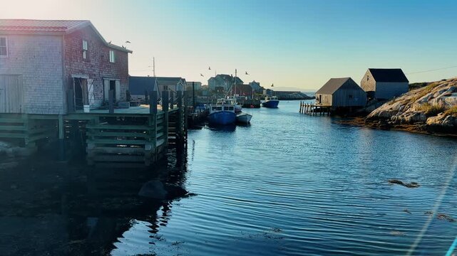 Exploring Peggy's Cove in Nova Scotia with boats and old buildings near the Atlantic Ocean in late afternoon sun