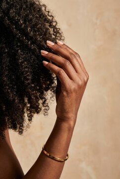 Black Woman Hands Lifting Curly Afro Hair Gold Bracelet Haircare