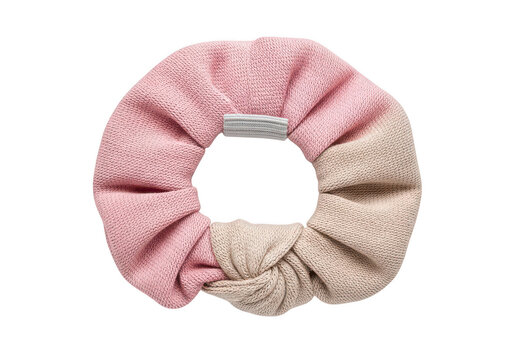 Knitted fabric hair scrunchie in soft pastel pink and beige tones with a decorative knot detail isolated on a transparent background