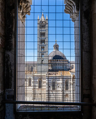 Naklejka premium Facciatone, Ausblick durch das Gitter im Turmfenster auf den Duomo di Siena, Toskana, Italien